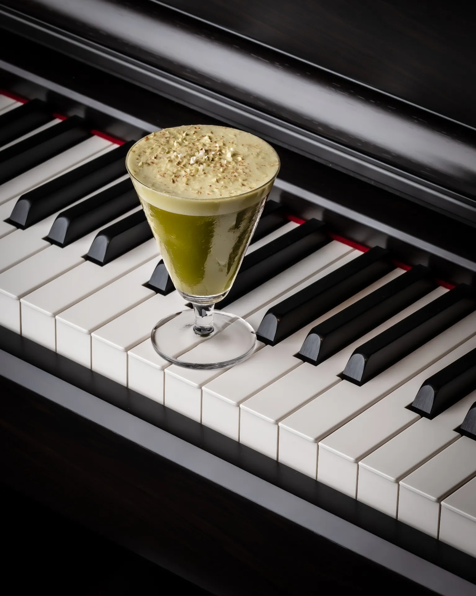 Green cocktail served on piano keys