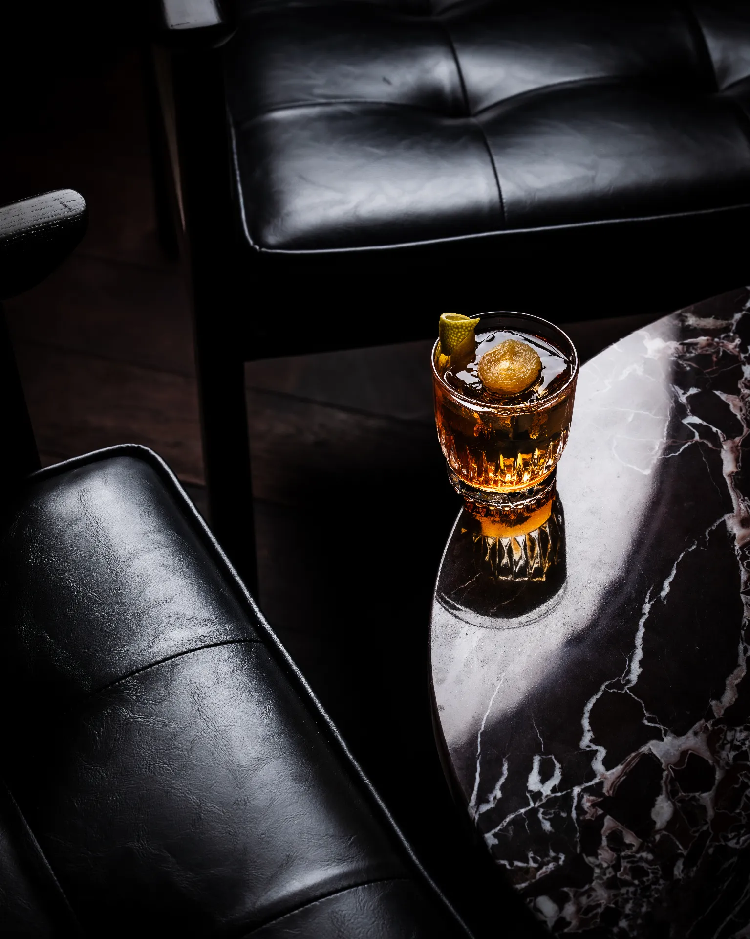 Old fashioned with a single sphere of ice on marble
